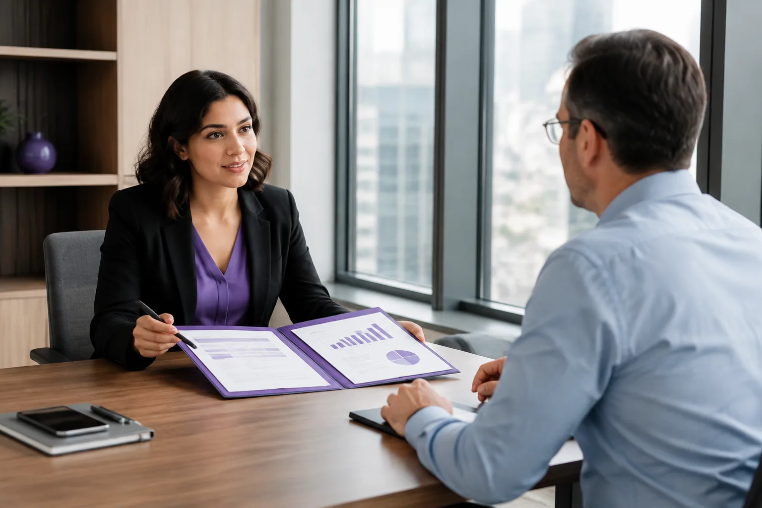 An employee presents accomplishment charts during a calm compensation meeting with a manager