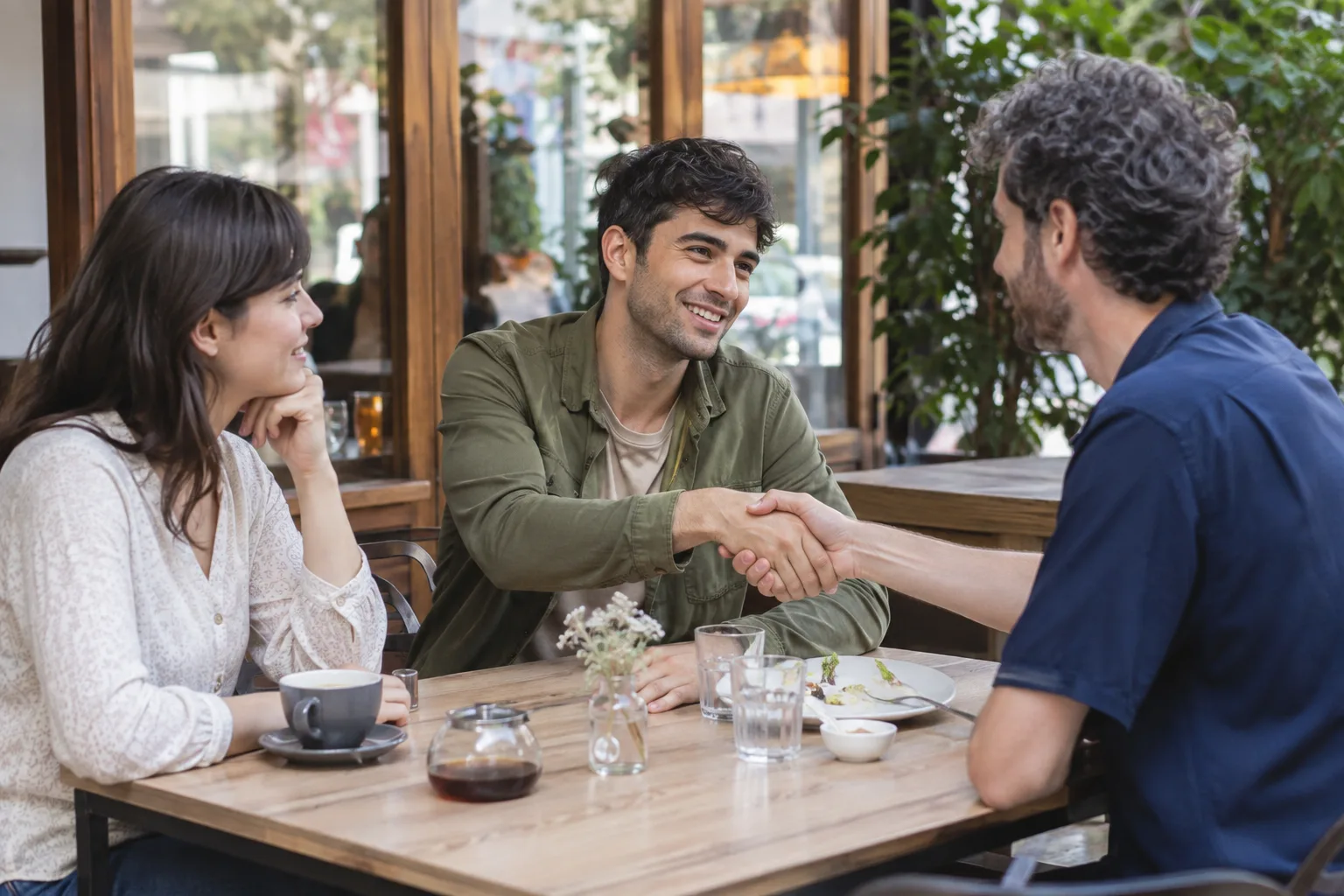 A current couple meets a former partner at a cafe while one partner considers the friendship thoughtfully